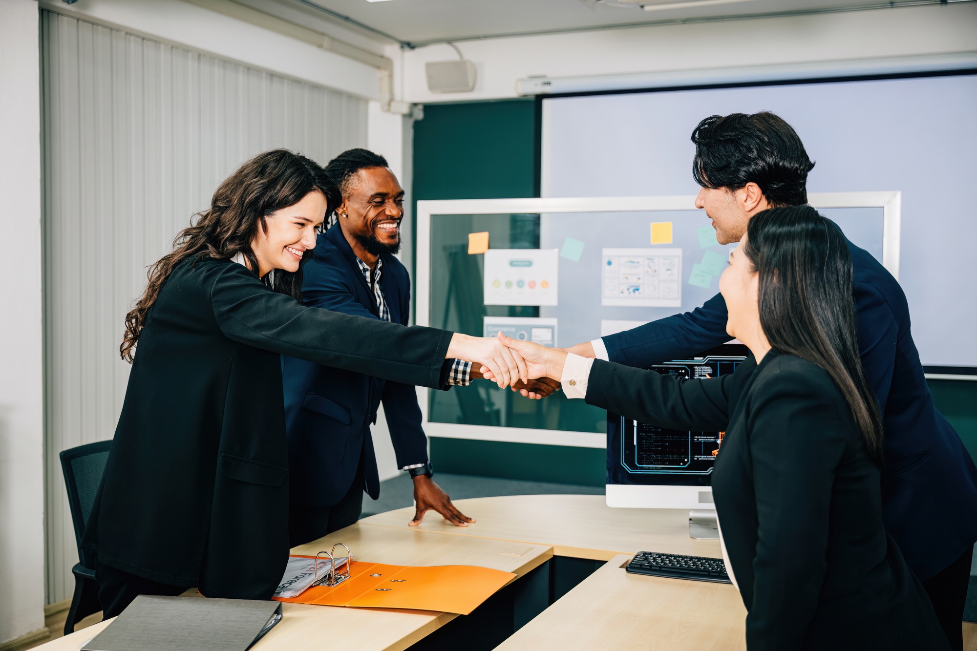 Businessmen sealing a deal with a handshake in an office. Colleagues, including executives, lawyers